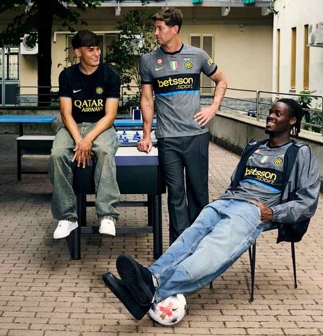 Trois amis en maillots de football dans une cour
